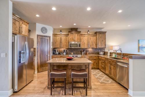 a kitchen with wooden cabinets and stainless steel appliances at Deschutes Landing at the Old Mill Riverfront - Meredith Lodging in Bend