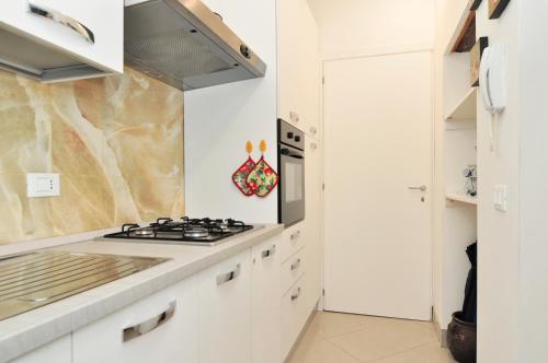 a kitchen with white cabinets and a stove top oven at COZY APARTMENT NEAR RIALTO BRIDGE/ ST.MARK SQUARE in Venice
