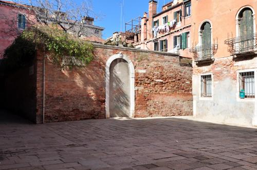 a brick wall with an archway in a building at COZY APARTMENT NEAR RIALTO BRIDGE/ ST.MARK SQUARE in Venice
