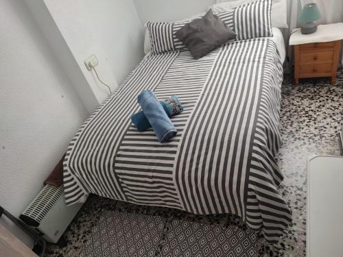 a black and white bed with two pillows on it at SUNSET ROOM AT FRONT BEACH - HABITACION EN LA PLAYA en Piso compartido in Tavernes de Valldigna