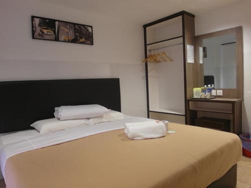 a bedroom with a bed with two pillows on it at Comfort Two Hotel in Melaka