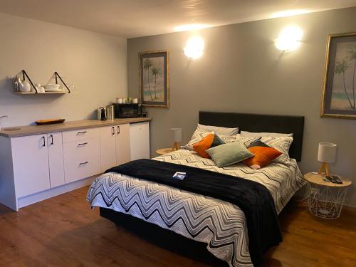 Un dormitorio con una cama con almohadas. en Opanuku Out West, en Auckland