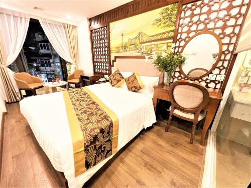 a bedroom with a bed and a desk and a mirror at DE LA SOIE Hotel & Travel in Hanoi