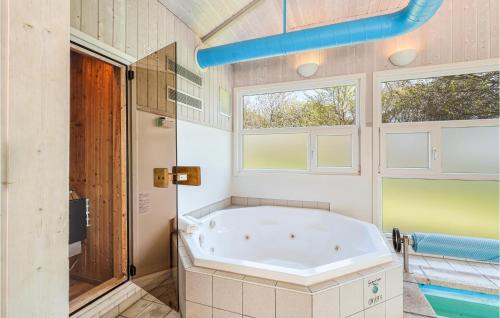 eine große Badewanne im Bad mit Fenstern in der Unterkunft Poolhaus 1 In Hohendorf in Hohendorf