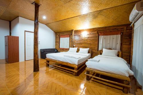 1 dormitorio con 2 camas y sofá en Panya Garden Resort, en Ban Huai Na