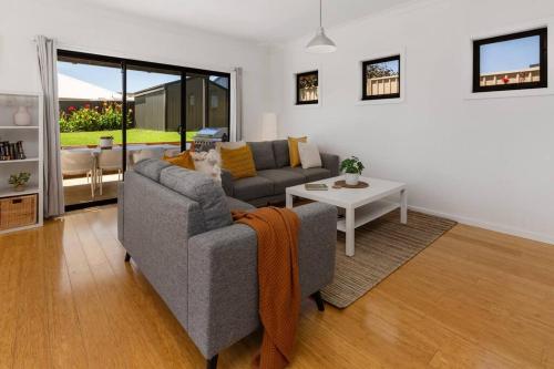 a living room with a couch and a table at Oriana Grande- 5 Bdrm Sleeps 14 Beach View Wifi in Sellicks Beach
