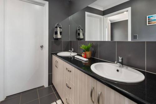 a bathroom with two sinks and a mirror at Oriana Grande- 5 Bdrm Sleeps 14 Beach View Wifi in Sellicks Beach
