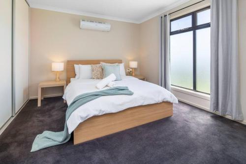 a bedroom with a large bed and a large window at Oriana Grande- 5 Bdrm Sleeps 14 Beach View Wifi in Sellicks Beach