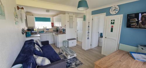 a living room with a couch and a kitchen at Isle of Wight Chalet in Sandown