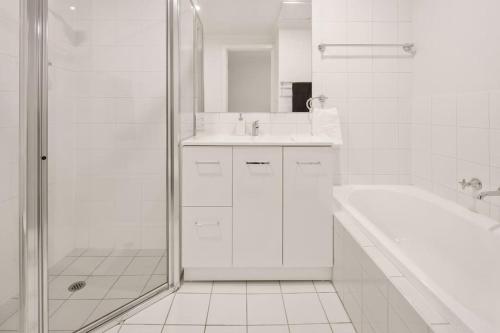 La salle de bains blanche est pourvue d'une douche et d'un lavabo. dans l'établissement Sparrow's Sanctuary 2 Brdms Parking Wifi, à Adélaïde