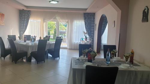 a dining room with tables and chairs and a window at Pensiunea Vila Maria in Crăcăoani