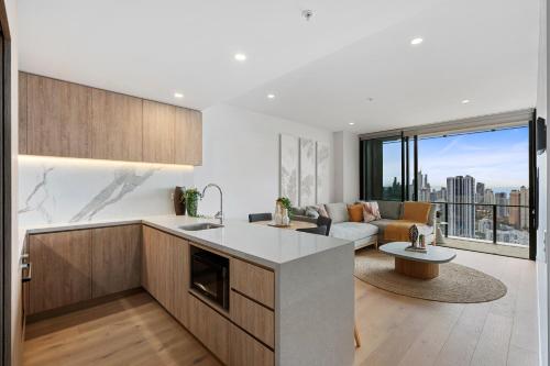 an open kitchen and living room with a couch at Broadbeach Casino Private Apartments - gclr in Gold Coast