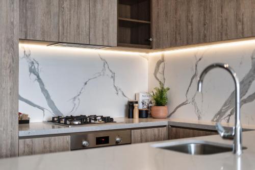 a kitchen with a sink and a stove at Broadbeach Casino Private Apartments - gclr in Gold Coast