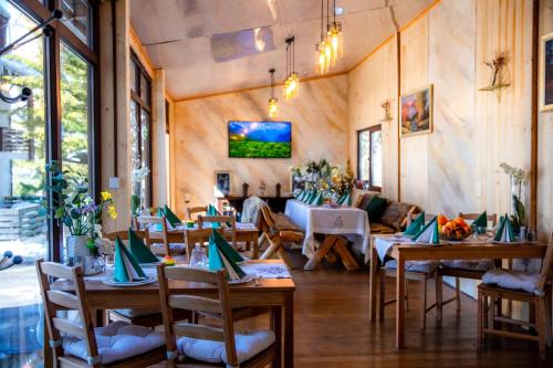 - une salle à manger avec des tables et des chaises dans l'établissement Cabana Din Poienita, à Poiana Brasov