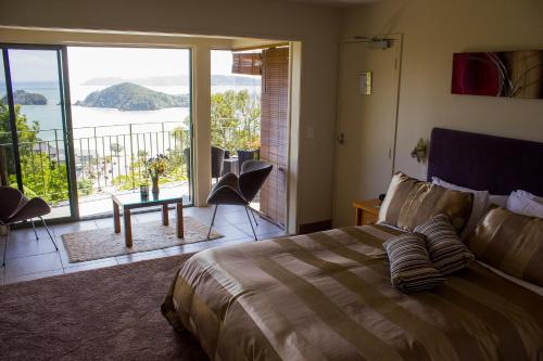 a bedroom with a bed and a view of the water at Allegra House in Paihia
