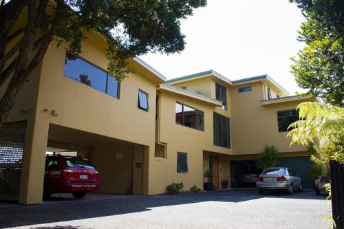 a yellow building with cars parked in front of it at Allegra House in Paihia