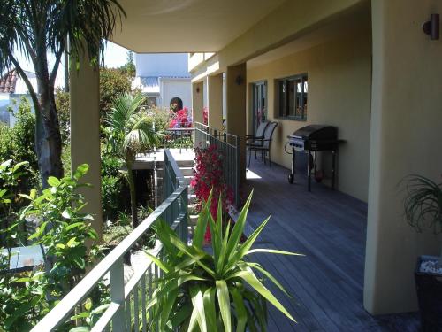 a balcony of a house with a piano and plants at Allegra House in Paihia