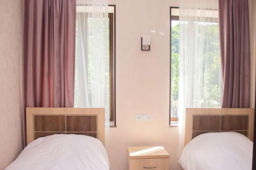 - une chambre avec 2 lits et une fenêtre dans l'établissement Spitak tun, à Ijevan