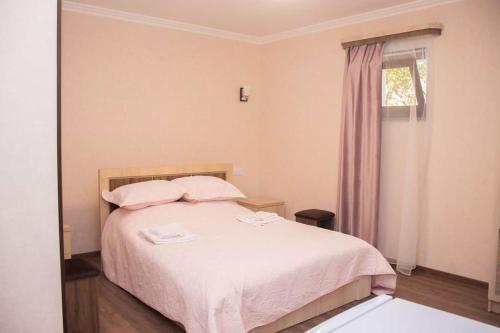 1 dormitorio con cama con sábanas rosas y ventana en Spitak tun en Ijevan