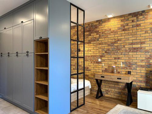 een badkamer met een bakstenen muur en een spiegel bij BP Apartment in Toruń
