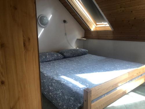 uma cama num pequeno quarto numa pequena casa em Tulipán ház em Szentendre