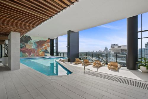 a pool on the roof of a building with a view at Broadbeach Casino Private Apartments - gclr in Gold Coast