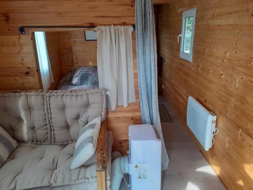 ein Zimmer mit einem Sofa und einem Fenster in einer Hütte in der Unterkunft Roulotte in Nîmes