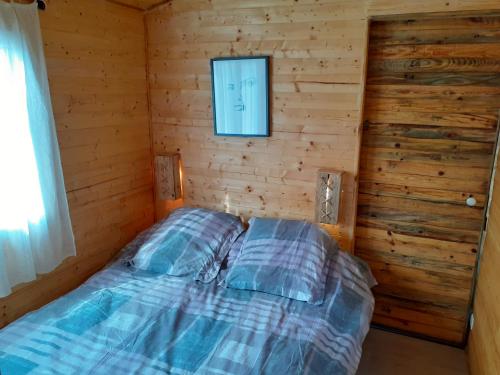 a bedroom with a bed in a log cabin at Roulotte in Nîmes