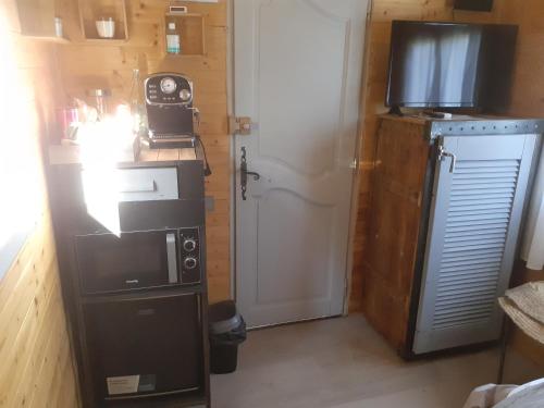 a small kitchen with a microwave and a refrigerator at Roulotte in Nîmes