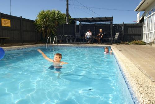 un niño y una niña nadando en una piscina en Richmond Motel and Holiday Park, en Richmond