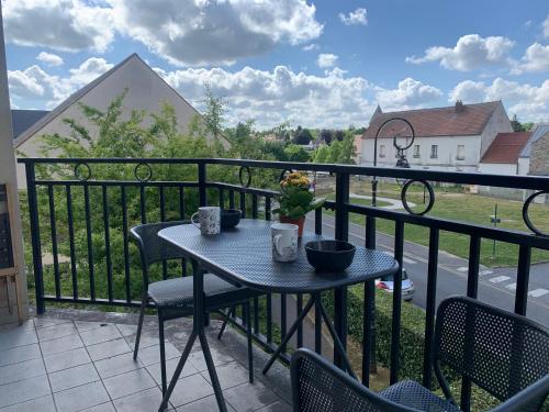 ein Tisch und Stühle auf einem Balkon mit Aussicht in der Unterkunft Luxury Appartement Disneyland in Magny-le-Hongre