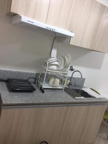a kitchen counter with a dish drying rack with dishes at Inspiria in Davao City