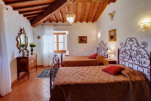 1 dormitorio con 2 camas, tocador y espejo en Il Frantoio delle Grazie, en Florencia