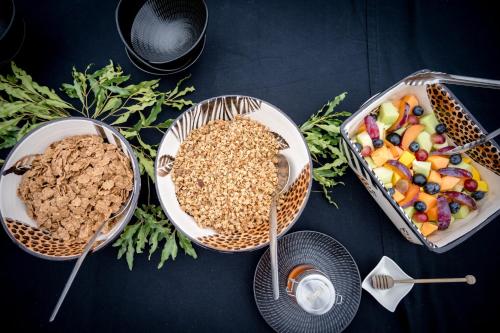 a table with three baskets of food and a tray of fruit at Makumu Private Game Lodge in Klaserie Private Nature Reserve
