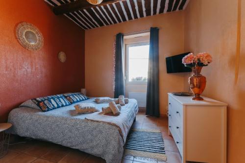 een slaapkamer met een bed en een vaas met bloemen bij Provence Now in Cabrières-dʼAvignon