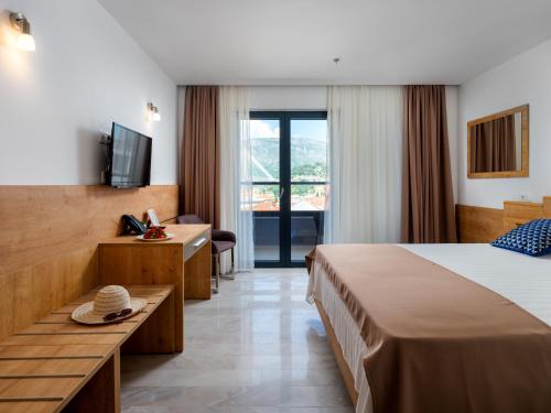 una camera d'albergo con un letto e una televisione di Hotel D'Elegant Dubrovnik a Dubrovnik