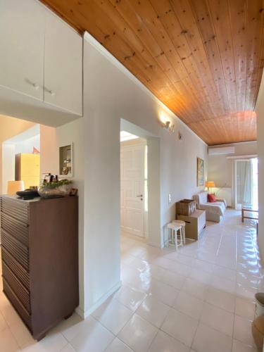 a kitchen and living room with a wooden ceiling at Mata's Spacious Apartment in Astros