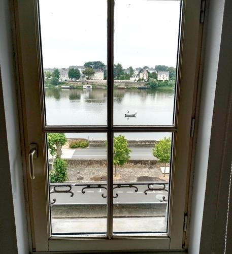 an open window with a view of a lake at T2 vue sur Loire local vélo in Saumur