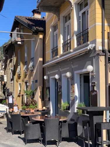 a patio with tables and chairs in front of a building at Ferienhaus, Rustico Auf Burg in Locarno