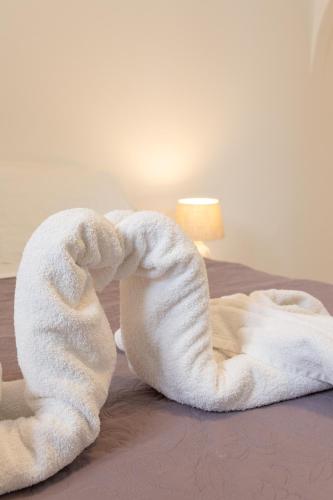 a white towel shaped like a heart sitting on a bed at Villa Katerina in Parikia
