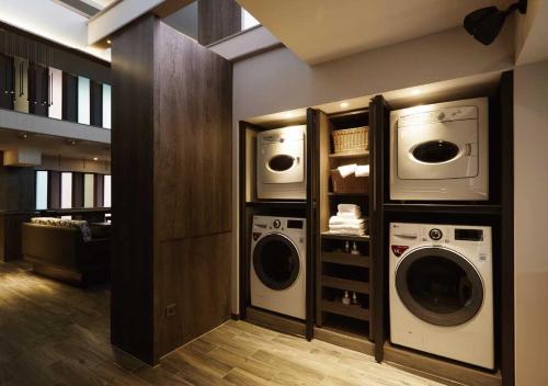 a laundry room with two washes and two microwaves at At Home Hotel Ximen in Taipei