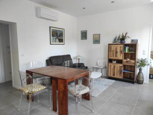 un salon avec une table et des chaises en bois dans l'établissement Maison avec jardin à 5 minutes à pied des plages, à La Ciotat
