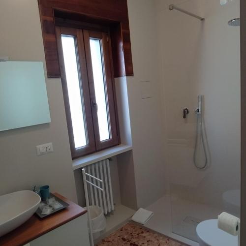 a bathroom with a sink and a shower with a window at Apartments for you in Matera