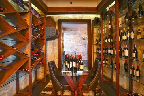 a bar with two chairs and a table with bottles of wine at Diplomat Hotel by AG Hotels Group in Astana