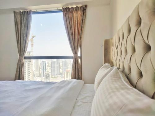 a bedroom with a bed with a large window at LARGE 1BR APARTMENT with SPACIOUS BALCONY OVERLOOKING THE DUBAI MARINA in Dubai