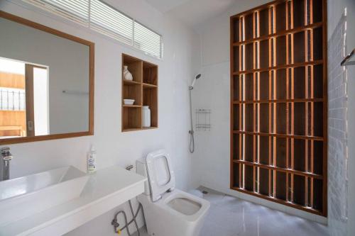 un bagno con un water, un lavandino e uno specchio di Nutnicha river house a Lam Phaya