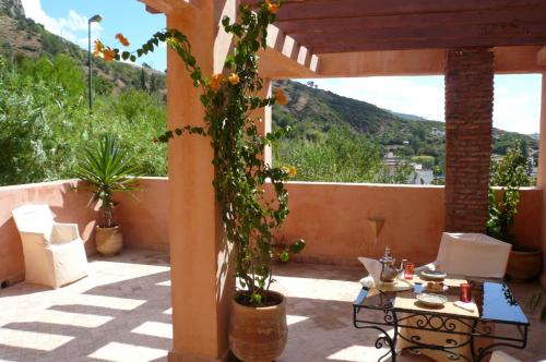 a patio with a table and a view of a mountain at Dar Rass El Maa in Chefchaouene