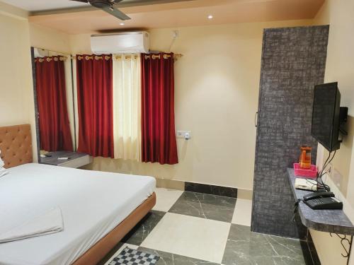 um quarto de hotel com uma cama e uma televisão em STAYMAKER Addyama - Only Indian Citizens Allowed em Calcutá