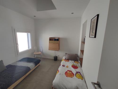 une petite chambre avec deux lits et une fenêtre dans l'établissement Maison avec jardin à 5 minutes à pied des plages, à La Ciotat