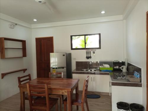 a kitchen with a wooden table and a refrigerator at Portofino Panglao Bohol in Panglao